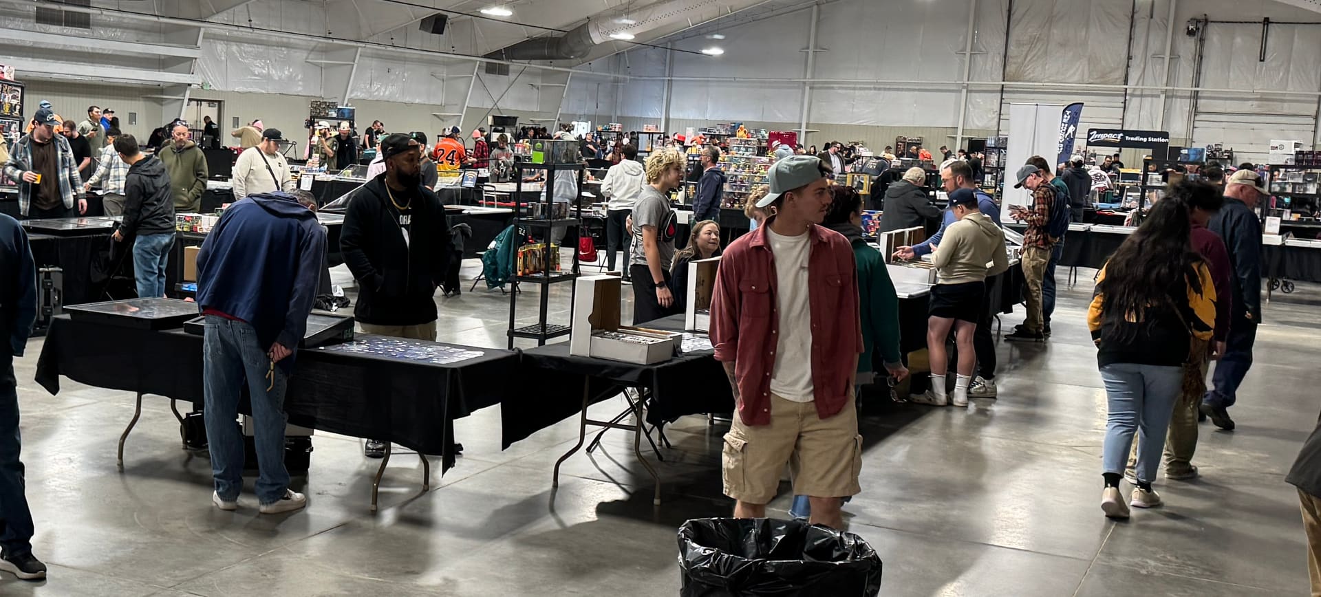 A wide view of the Pikes Peak Card Show floor — rows of vendor tables and collectors browsing across the hall at Norris Penrose Event Center